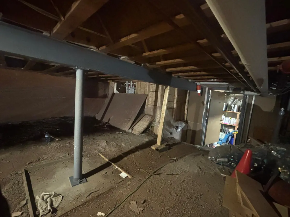 Steel beam and support posts installed beneath an existing floor